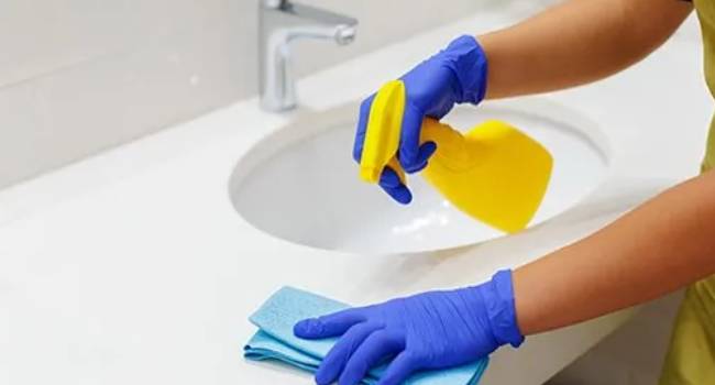Professional bathroom deep cleaning around a sink and counter
