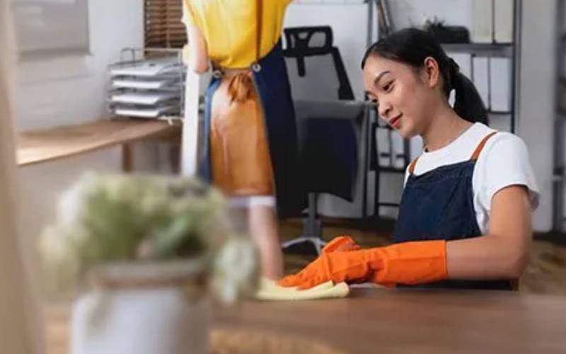 Professional cleaner wiping a desk in a living or office space