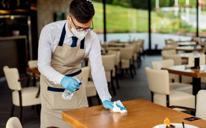 Professional cleaner wiping a breakroom table