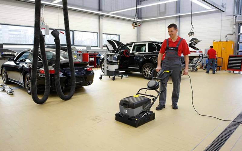 Professional cleaning service maintaining a car dealership service area