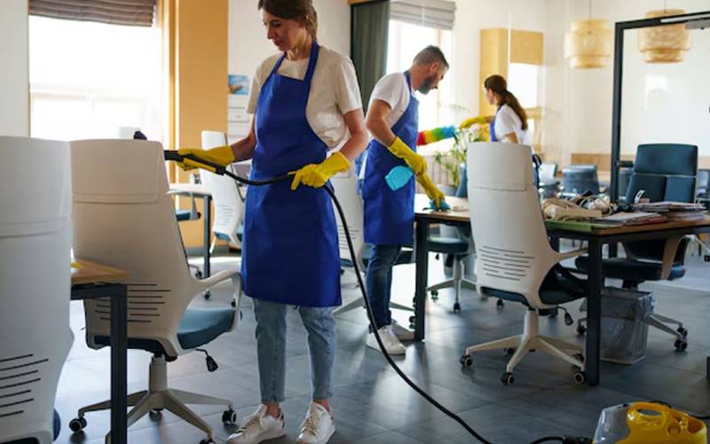 Professional cleaners disinfecting an office workspace