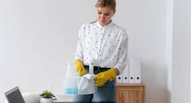 Professional cleaner wiping and disinfecting an office desk