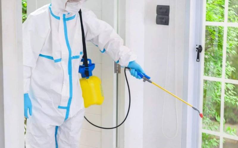 Professional disinfecting service spraying an entryway