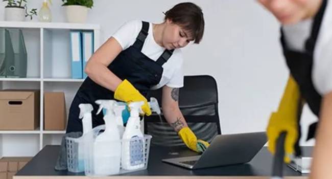 Professional eco-friendly office cleaner wiping a desk