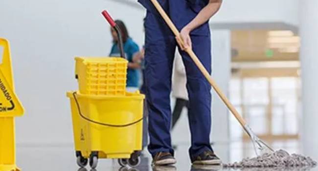 Professional cleaner mopping a commercial office floor
