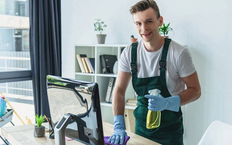 Professional cleaner wiping an office desk