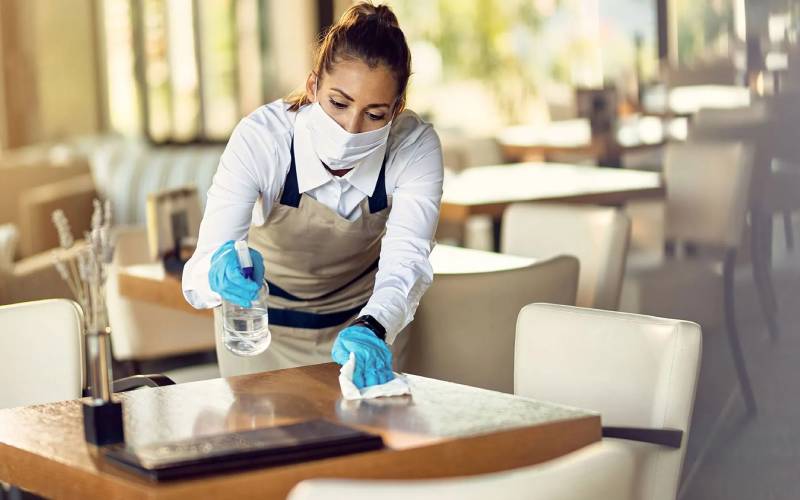 Professional cleaner wiping a table surface