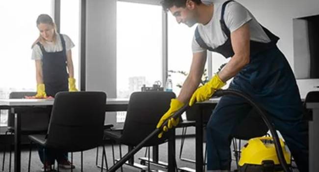Professional cleaners vacuuming and cleaning an indoor room