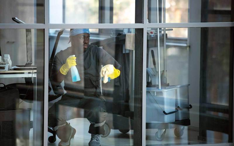 Professional cleaner cleaning office windows