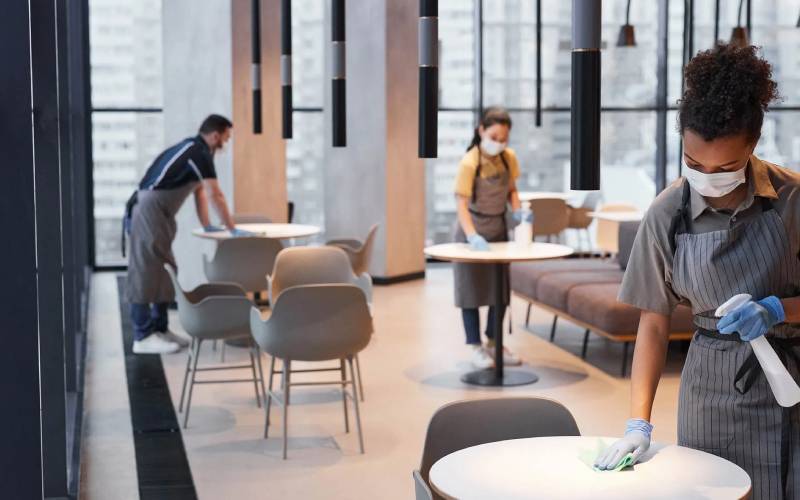 Professional cleaner wiping a breakroom or dining room table