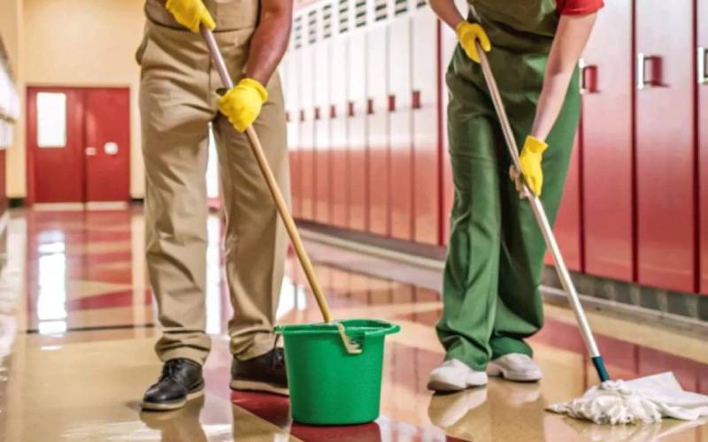School janitorial team mopping a hallway