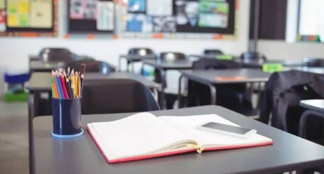 Clean school desk with notebook and supplies