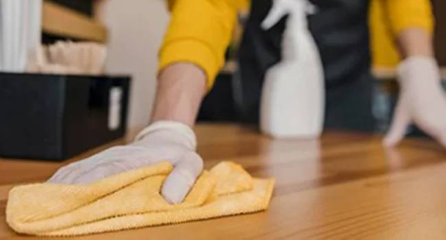 Professional cleaner wiping a commercial kitchen surface